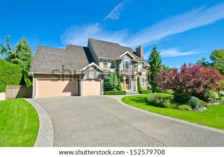Big custom made luxury house with nicely landscaped front yard and long driveway in the suburbs of Vancouver, Canada.