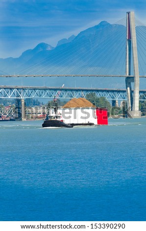 A tug boat towing barge loaded with cargo. Vancouver, Canada. Vertical.