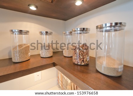 Fragment of the luxury modern kitchen with some shelves with jars, cans in the corner. Interior design.
