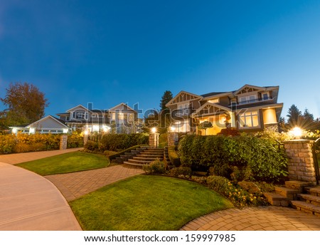 Great neighborhood. Luxury houses with nicely  paved doorway at dusk, night time in suburbs of Vancouver, Canada.
