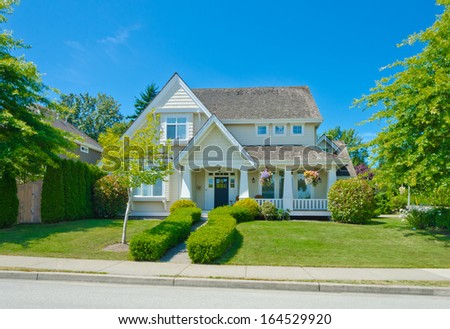 Big custom made luxury house with nicely trimmed and landscaped front yard in the suburbs of Vancouver, Canada.