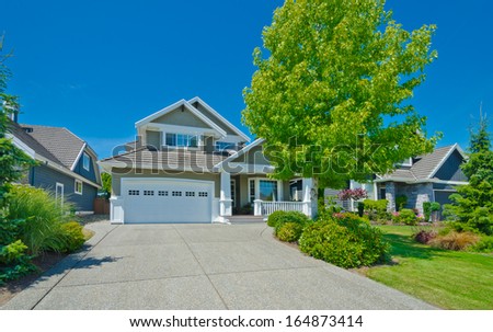 Big custom made luxury house with double doors garage and wide and long driveway in the suburbs of Vancouver, Canada.