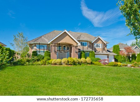 Big custom made luxury house with nicely landscaped and trimmed front yard in the suburbs of Vancouver, Canada.