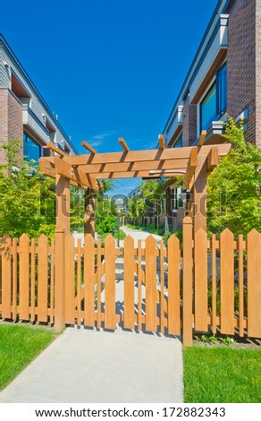 Wooden cedar yellow fence and gates to the townhouses  complex. Nice and comfortable neighborhood. Townhouses in the suburbs of the North America. Canada.