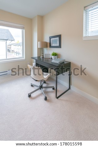 Luxury spacious modern nicely decorated den, home office with the table and the office chair. Interior design. Vertical.