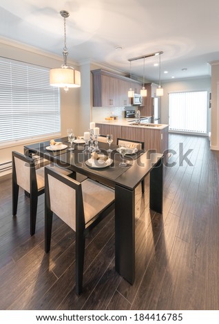 View, outlook, panorama at luxury living site. Nicely decorated dining table and the kitchen at the back. Interior design of a brand new house. Vertical.