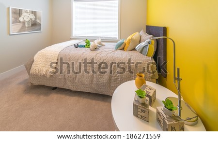 Modern nicely decorated bedroom for children painted in yellow. Interior design.