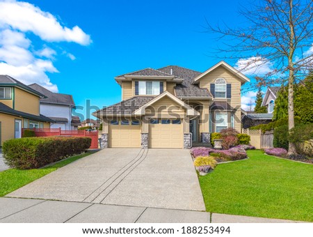 Big custom made luxury house with double doors garage, long and wide driveway and nicely trimmed and landscaped front yard in the suburbs of Vancouver, Canada.