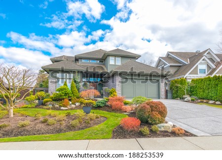 Big custom made luxury house with with double doors garage and nicely trimmed and landscaped front yard in the suburbs of Vancouver, Canada.