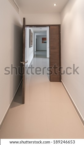 A corridor on the upper level of a house with the the rooms at the end. Interior design. Vertical.