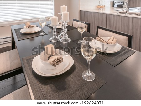 Luxury living site. Nicely decorated and served dining table with napkins and candle holders. Interior design of a brand new house.