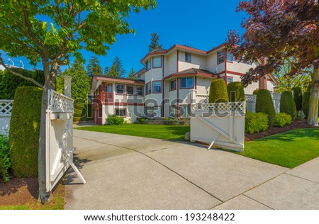 Custom built luxury house with nicely trimmed front yard, lawn and long driveway in a residential neighborhood. Vancouver Canada.
