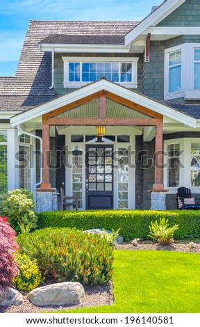 House entrance with nicely trimmed and landscaped front yard.