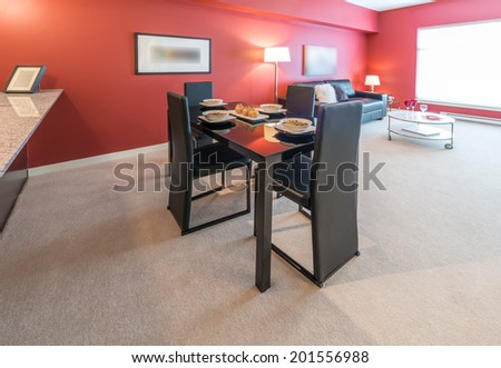Luxury living suite with red walls: nicely decorated and served with pasta and fruits dining table. Interior design.