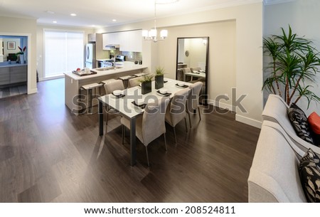 Nicely decorated dining table and the kitchen at the back. Interior design.