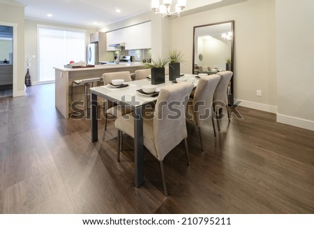 Nicely decorated dining table and the kitchen at the back. Interior design.