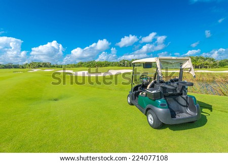 Golf cart, buggy at the golf course with the sand bunkers at the back. Luxury resort.