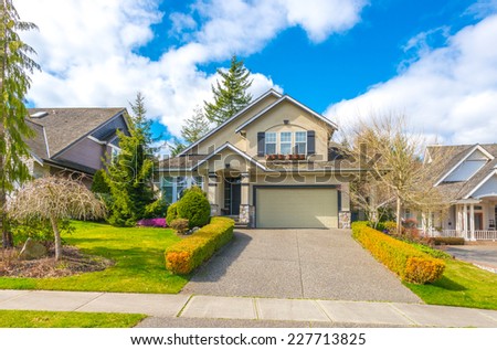 Big custom made luxury house with nicely landscaped front yard, double doors garage and long and wide driveway in the suburbs of Vancouver, Canada.