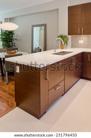 Luxury modern kitchen with dining table at the back. Interior design of a brand new house. Vertical.
