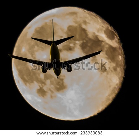 Night (dawn ) flight of the plane, jet with big moon as a background.