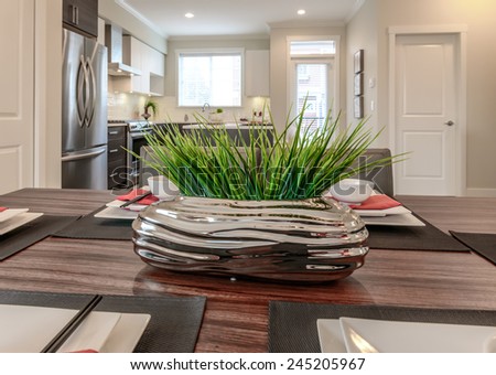 Decorative vase with some plants with the kitchen at the back. Interior design.