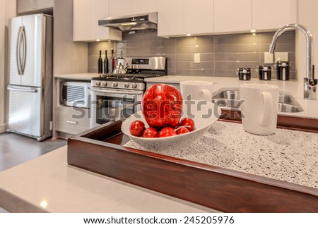 Nicely decorated kitchen counter with the tray with plate with some fruits and apple. Interior design.