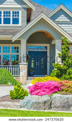 House entrance with nicely trimmed and landscaped front yard.