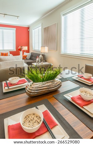 Fragment of the luxury living suite : nicely decorated dining table and the living room at the back. Interior design. Vertical.