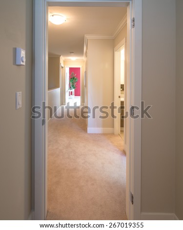 Perspective of corridor on the upper level of a house with the red colored room at the end. Interior design.