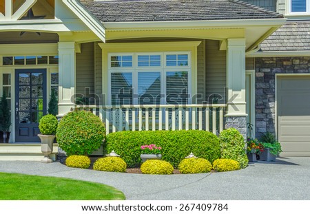 House entrance with porch and nicely trimmed and landscaped front yard.