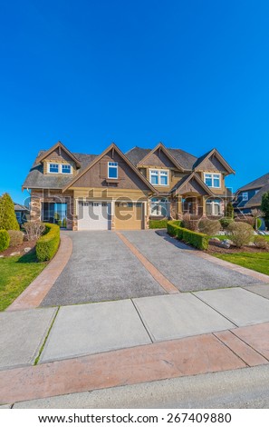 Big custom made luxury house with landscaped front yard and nicely paved driveway to garage in the suburb of Vancouver, Canada. Vertical.
