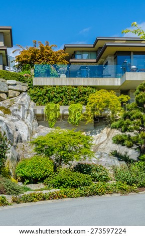 Big custom made luxury modern house on the rocks with nicely landscaped front yard in the suburbs of Vancouver, Canada. Vertical.