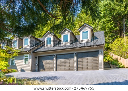 Double doors garage with wide, nicely paved driveway. North America. Canada.