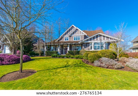 Big custom made luxury house with nicely landscaped and trimmed front yard in the suburbs of Vancouver, Canada.