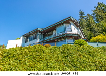 Custom built luxury house on the rock covered with plants in a residential neighborhood. Vancouver Canada.