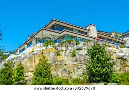 Big custom made luxury modern house on the rocks with nicely landscaped front yard in the suburbs of Vancouver, Canada.