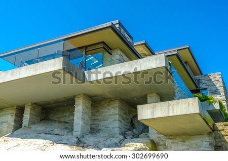 Fragment of the big custom made luxury modern house with nicely landscaped front yard in the suburbs of Vancouver, Canada.