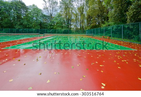 End of the season at tennis court covered with the leafs at autumn, fall time. Rainy day.