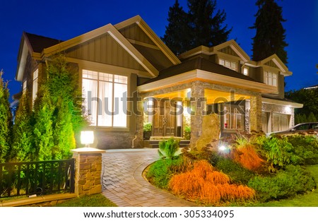 A luxury house with driveway  in suburbs at dusk, night, dawn time in Vancouver, Canada.