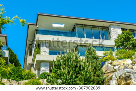 Big custom made luxury modern house on the rock with nicely landscaped front yard in the suburbs of Vancouver, Canada.