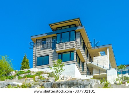 Big custom made luxury modern house under final stage of construction on the rock with nicely landscaped front yard in the suburbs of Vancouver, Canada.