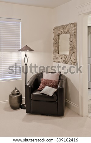 Leather chair with some pillows and a lamp stand in the corner of the room. Interior design. Vertical.