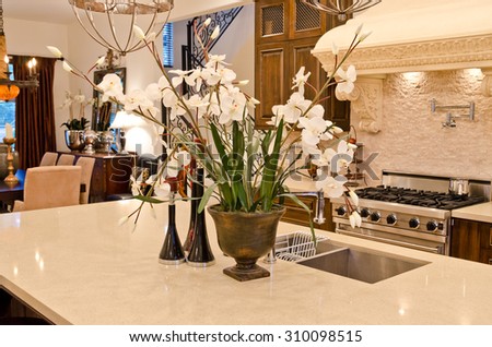 Some flowers, bouquet in the vase on the counter of a luxury modern kitchen. Interior design.