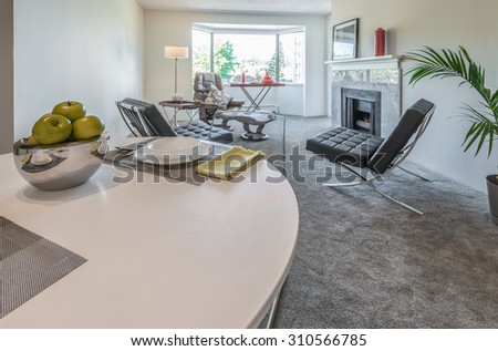 Nicely decorated dining table in the luxury modern kitchen with the living room at the back. Interior design.
