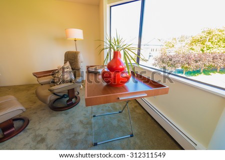 Nicely decorated tray, coffee table with vase on it in the corner of the living room. Interior design.