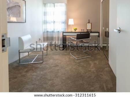 Luxury spacious modern nicely decorated den, home office with the table and the office chair. Interior design.