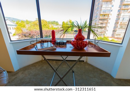 Nicely decorated tray, coffee table with vase on it in the corner of the living room. Interior design.
