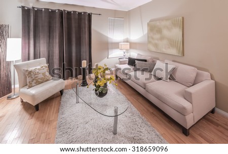 Interior design of luxury nicely decorated modern living room, suite with sofa, coffee table and chairs.