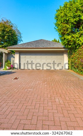 Double doors garage with long nicely paved driveway. North America.  Vertical.