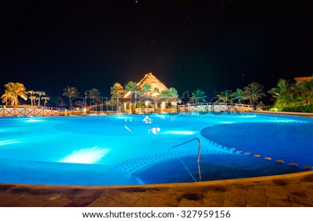Swimming pool at a luxury caribbean resort at night, dawn time.